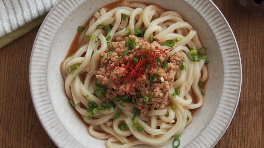 木のテーブルに置いた冷やし坦々混ぜうどん