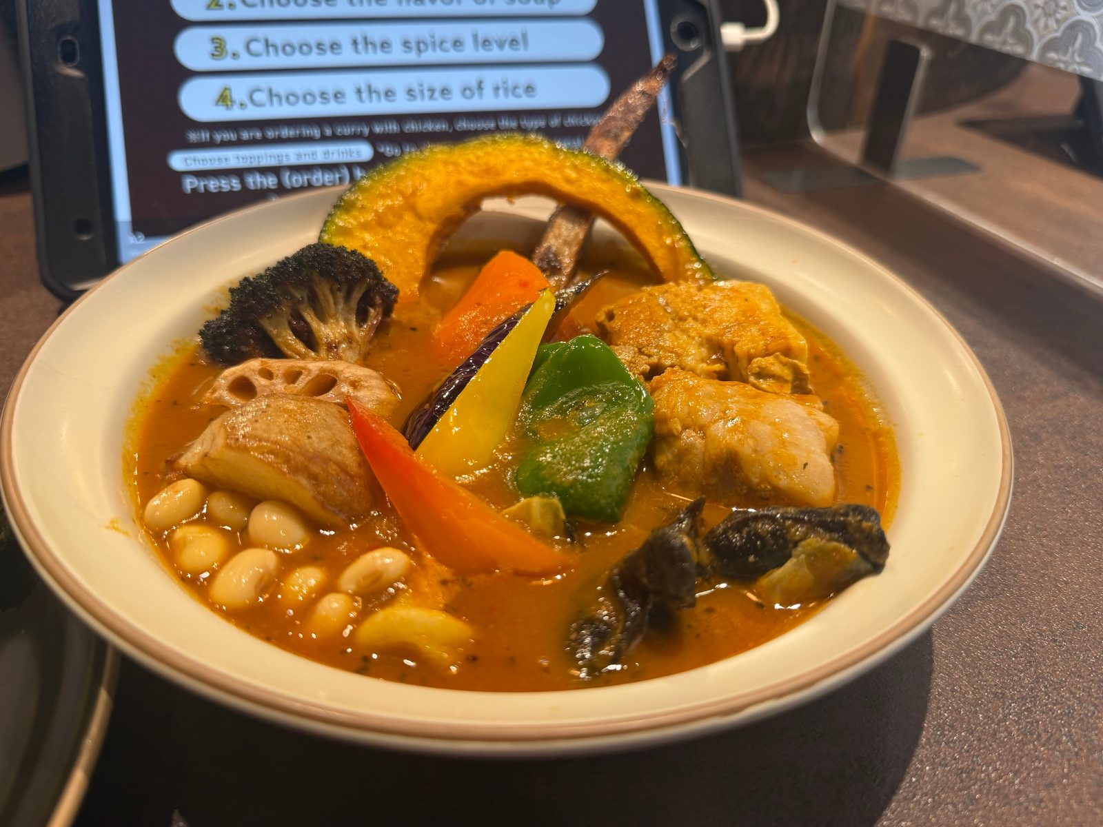 かぼちゃやれんこん、パプリカ、大豆などが入ったSAMURAI.のスープカレー